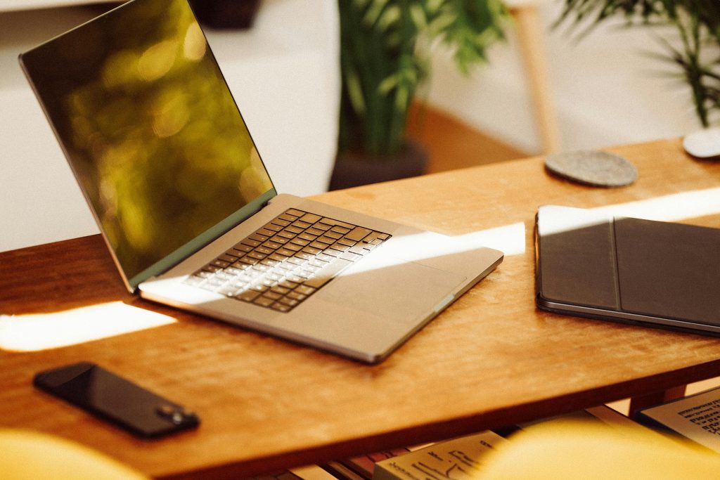Laptop and tablet on a wooden desk in a bright office